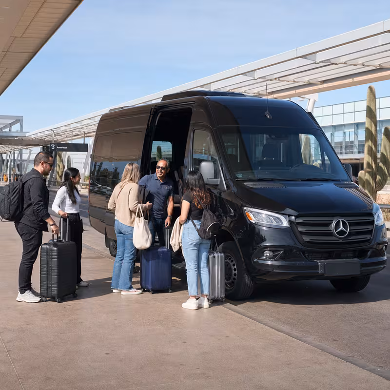 Group boarding a white charter bus for Airport Transportation transportation in Tucson
