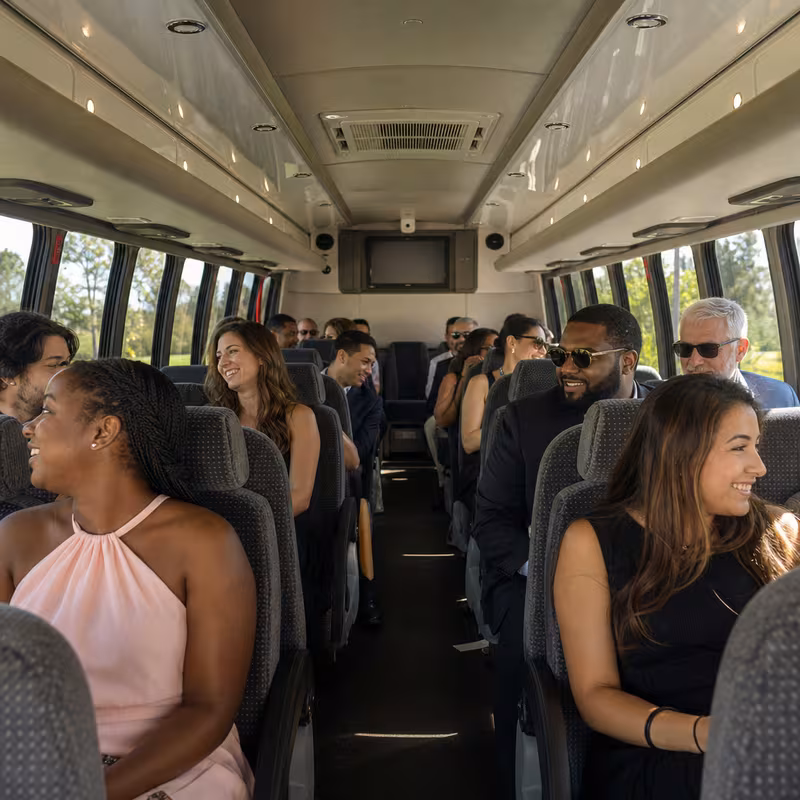 Group boarding a white charter bus for Private Event Transportation transportation in Tucson
