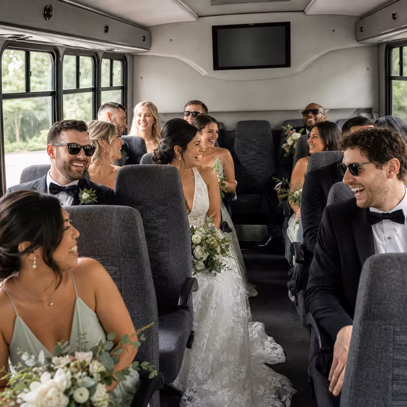 Group boarding a white charter bus for Wedding Transportation transportation in Tucson